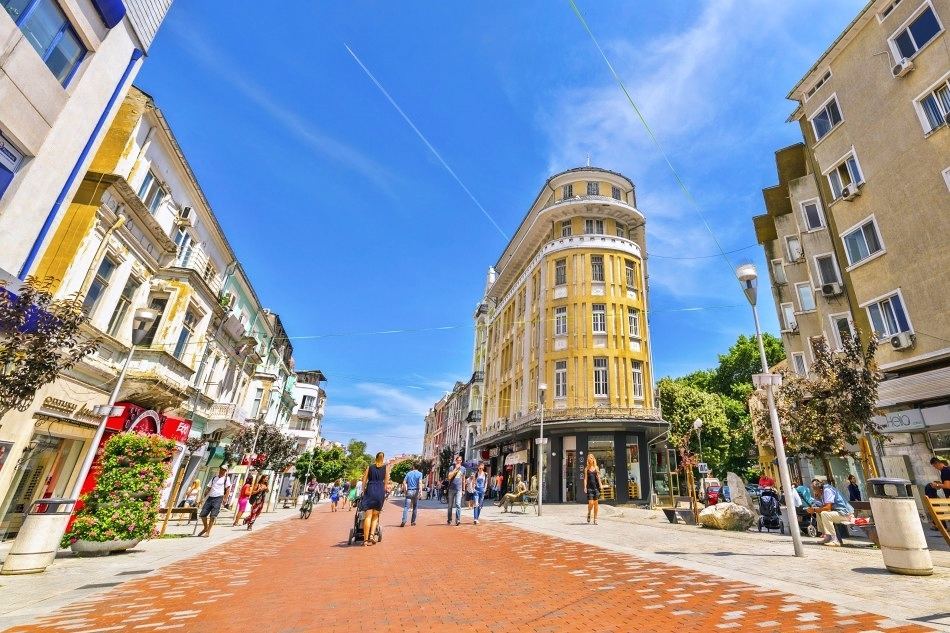 Pedestrian street with colourful buildings under a blue sky