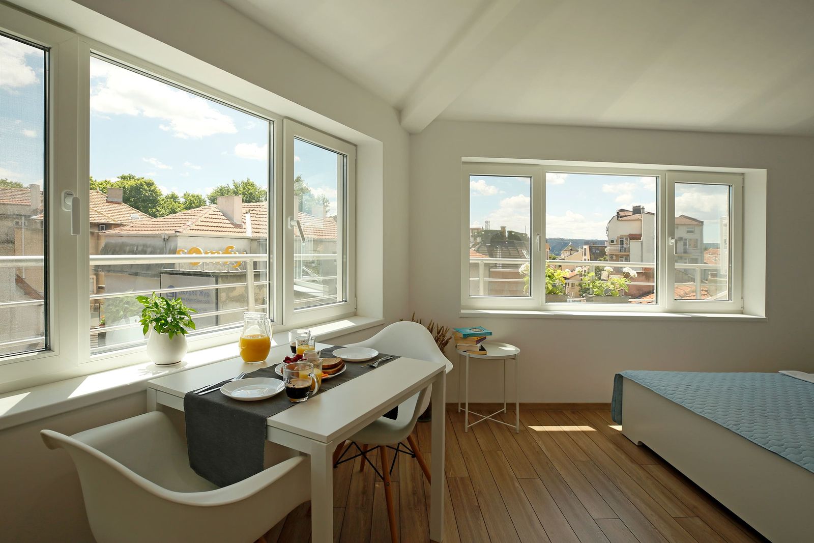 Breakfast table by the large windows with a view over the rooftops
