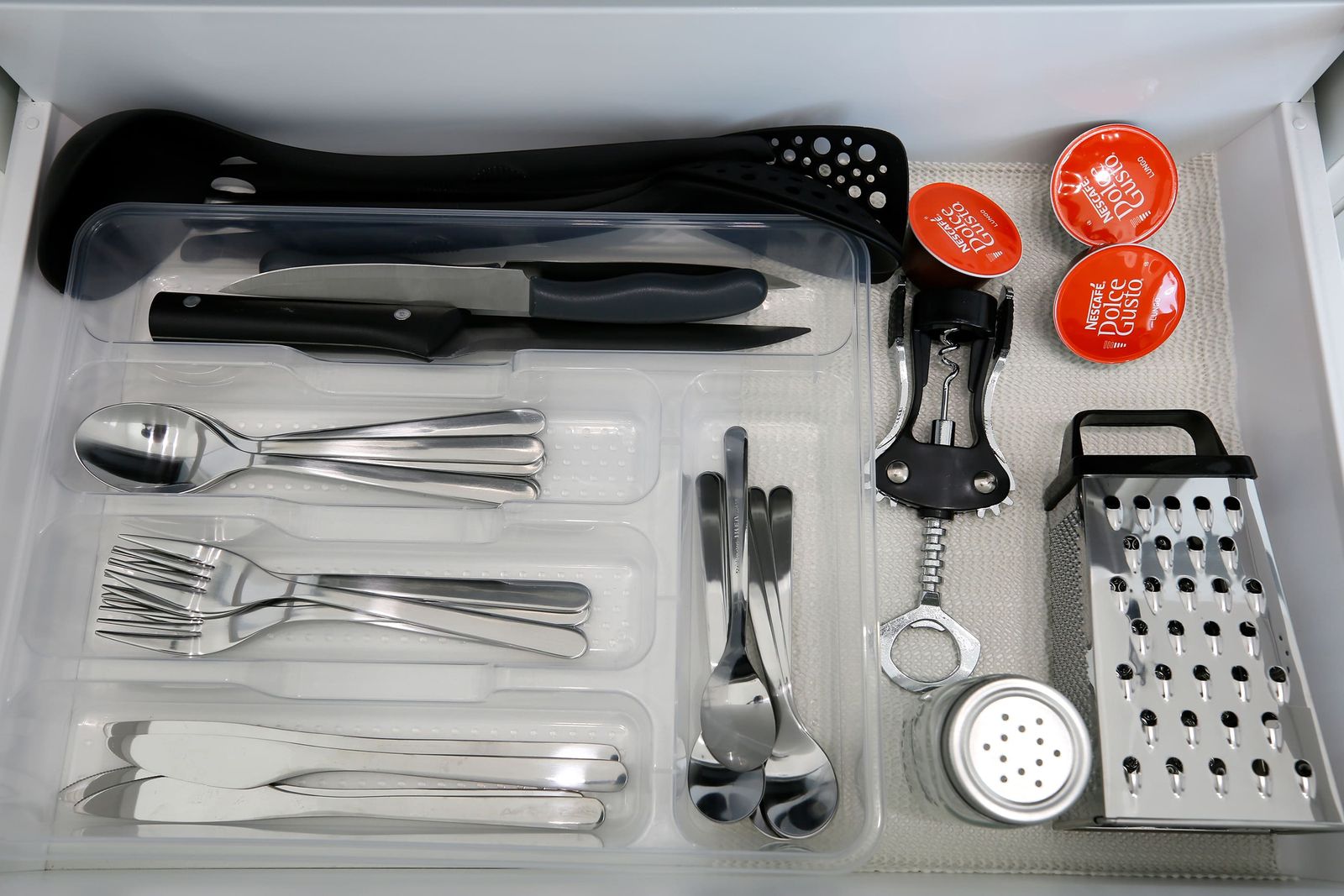 Kitchen drawer with cutlery, utensils and coffee capsules