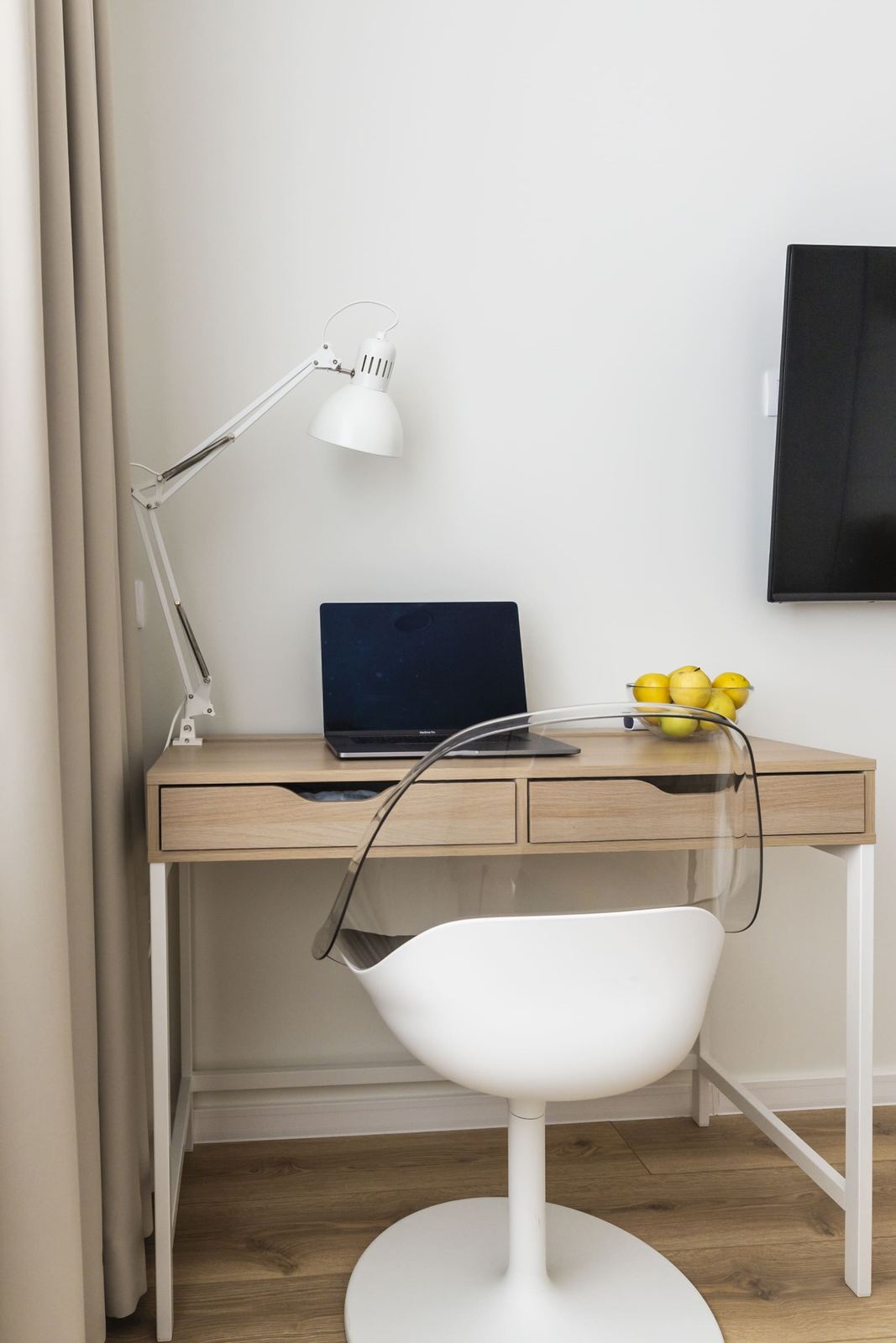 Desk with lamp, laptop and a clear chair