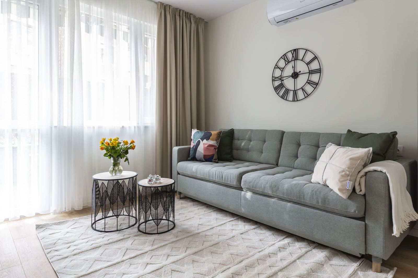 Living room with grey sofa, coffee tables and sheer curtains