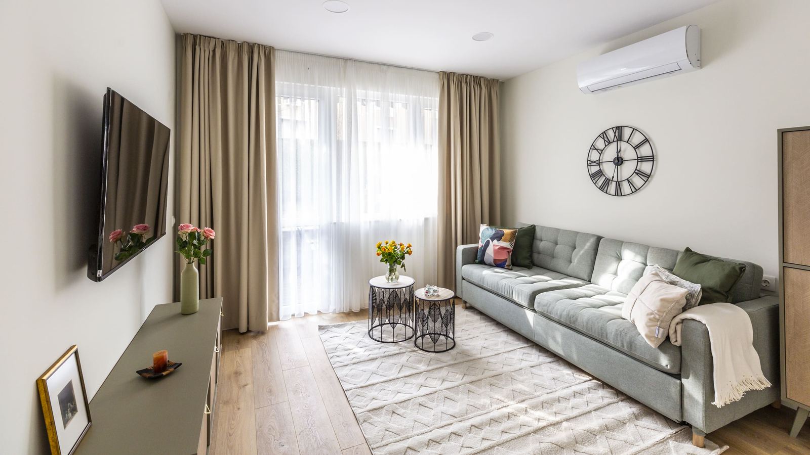 Living room with sofa, TV and a tall window