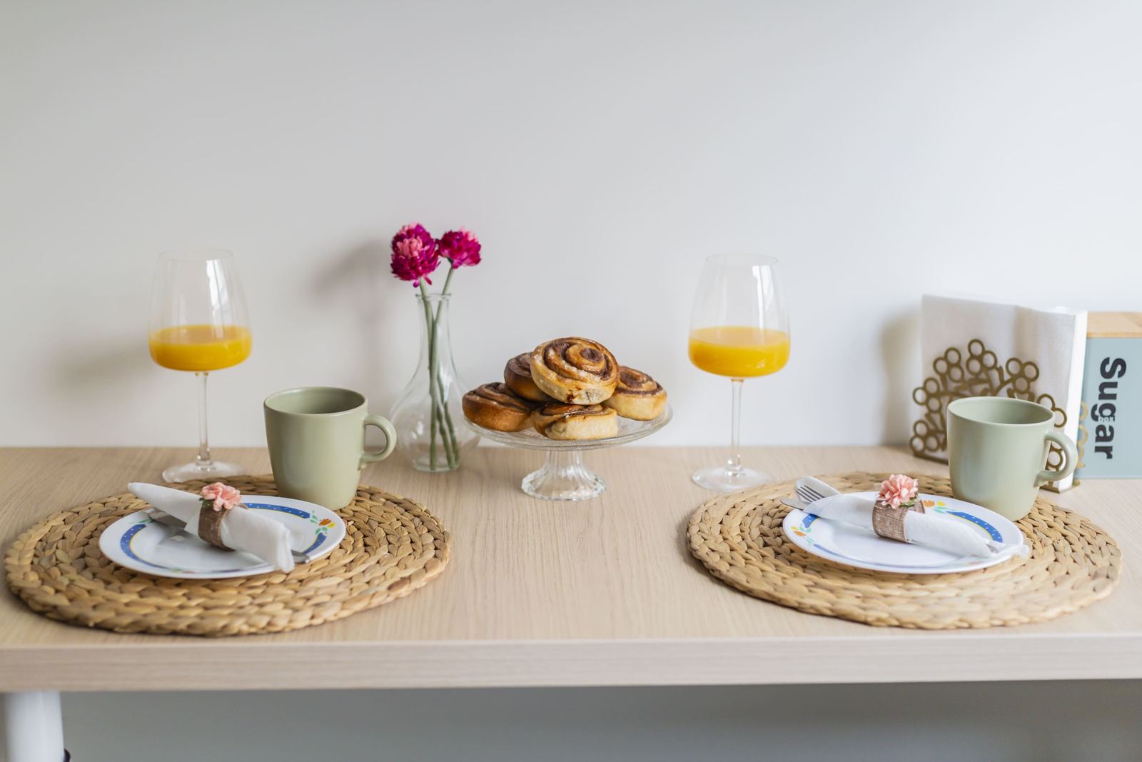 Breakfast table set with cinnamon rolls and orange juice