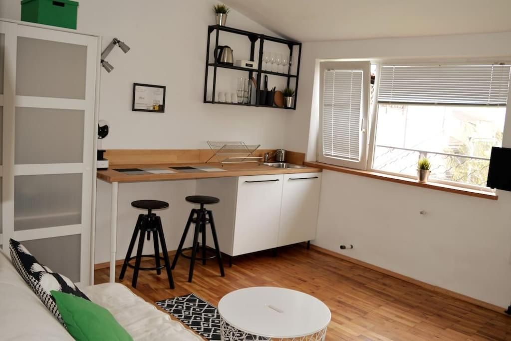 Kitchenette with breakfast bar, stools and a shelf by the window