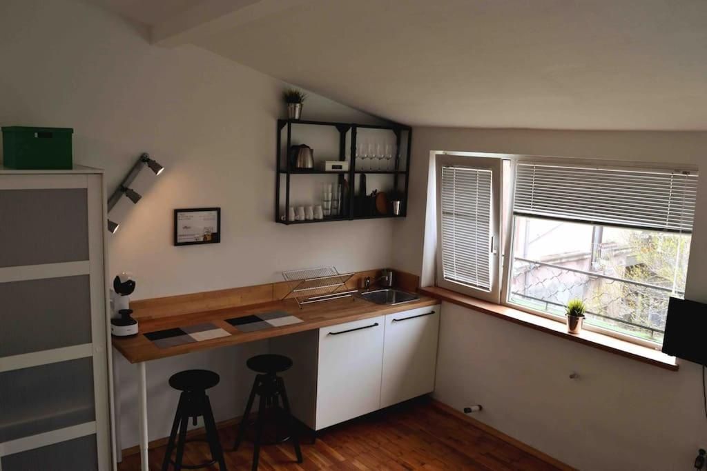Kitchen counter with sink, open shelf and window