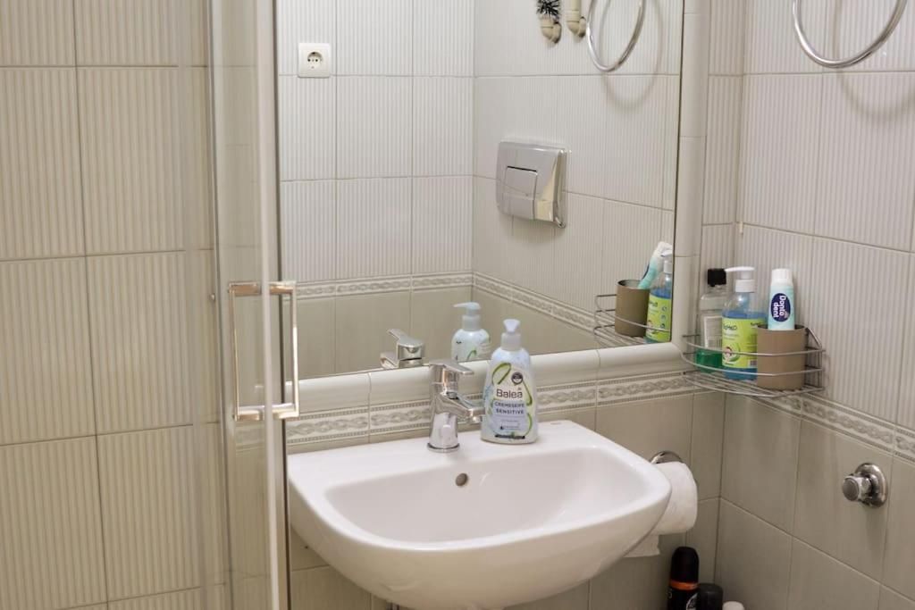 Bathroom with washbasin, mirror and shower door